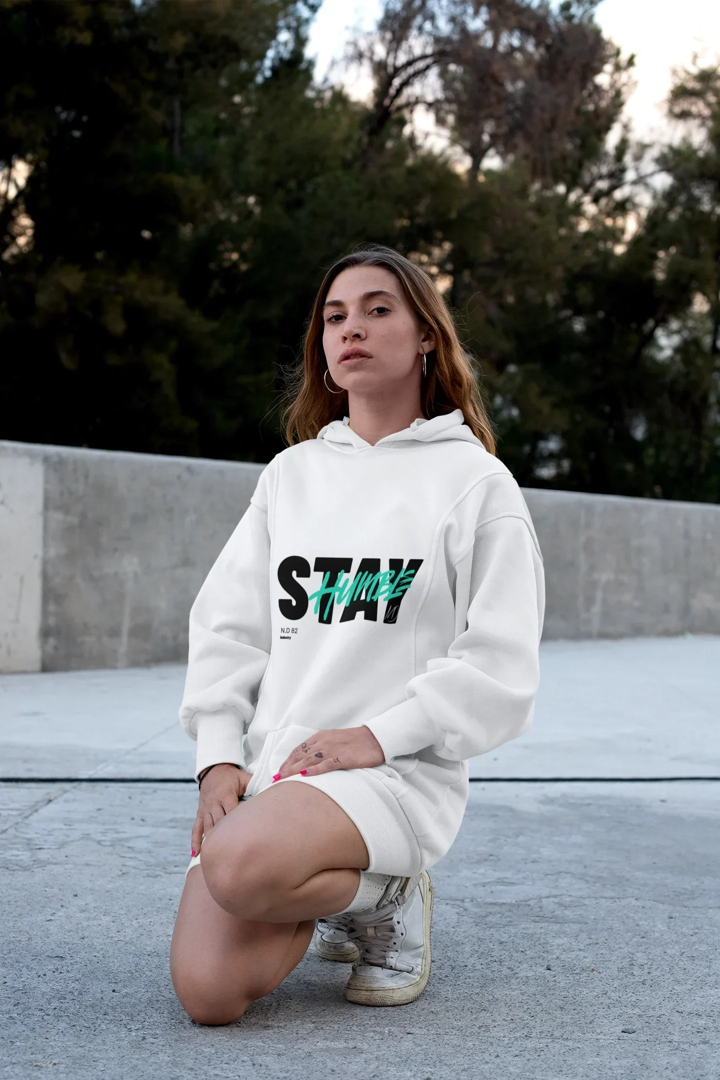 Model in weißem Stay-Hoodie im Freien