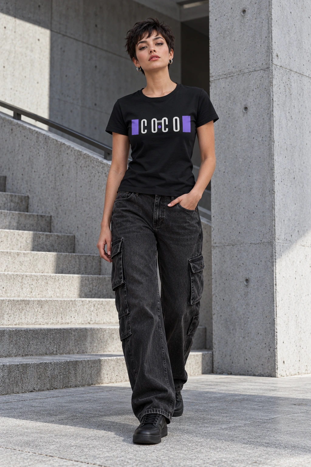 Model im schwarzen Coco-Loco-Shirt an einer Betontreppe